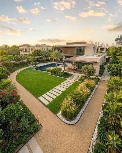 Aerial view of a landscaped garden with lawn, stepping stones and a pool beside a modern house